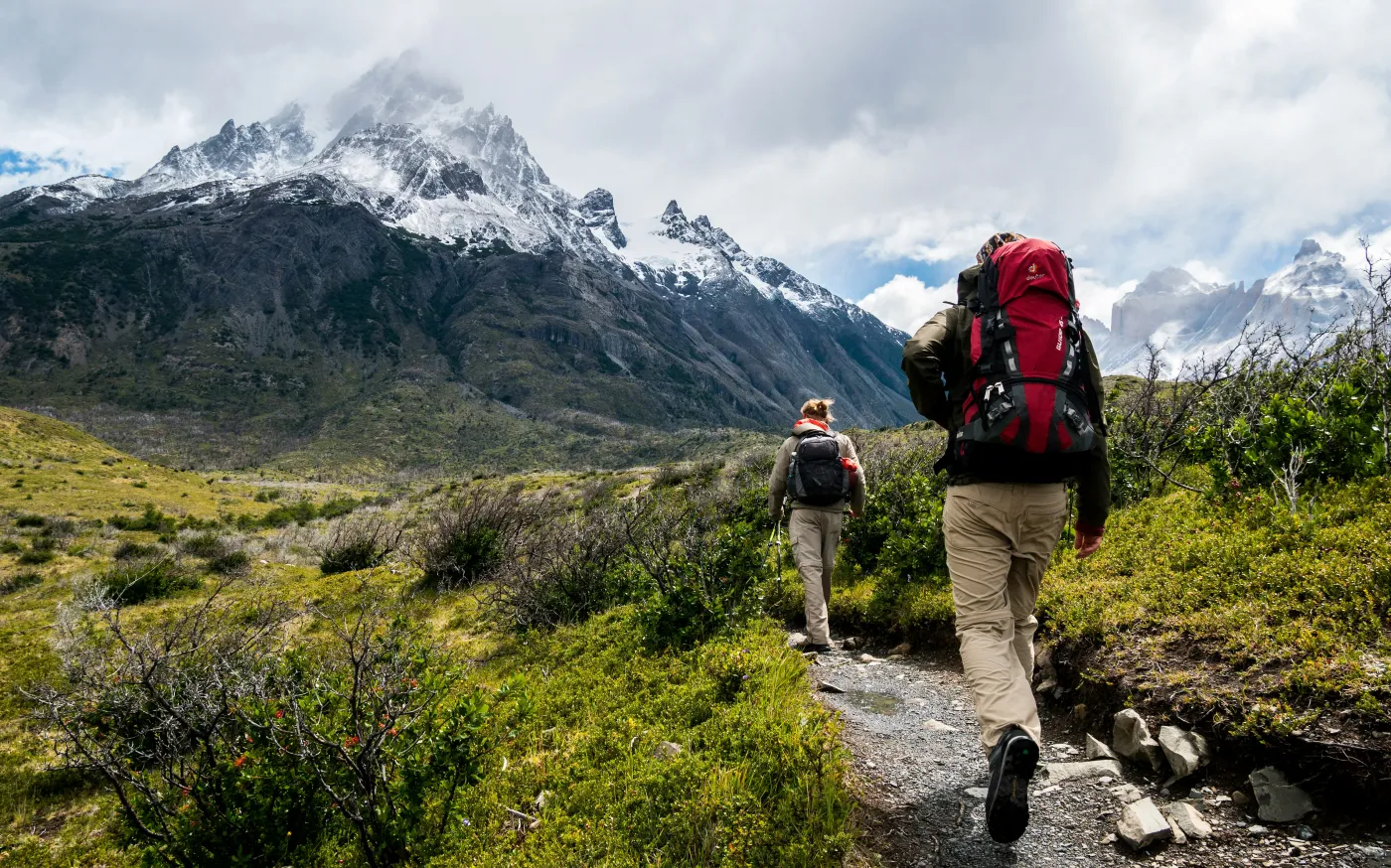 two person walking towards mountain covered with snow by Toomas Tartes courtesy of Unsplash.