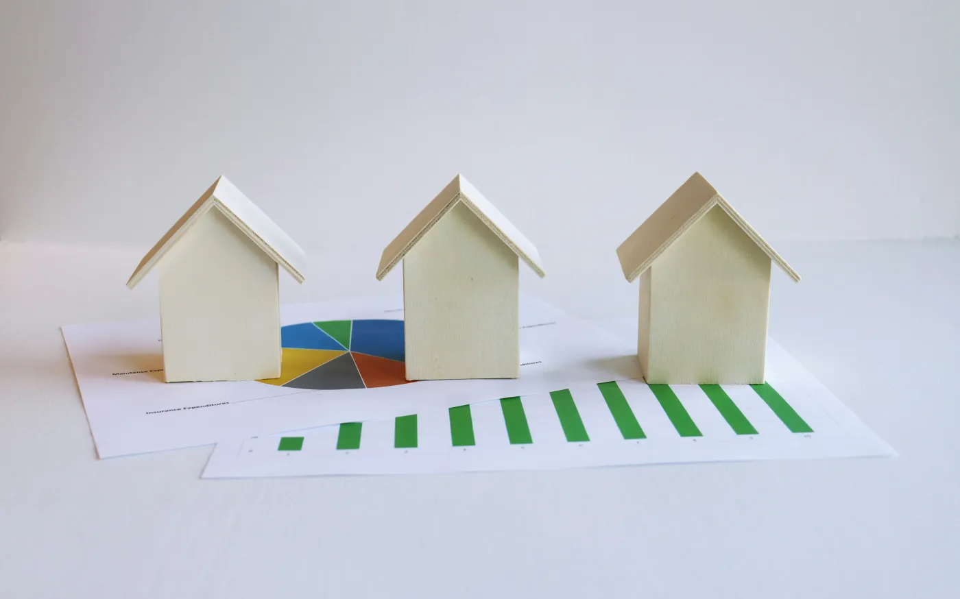 three small houses sitting on top of a piece of paper by Artful Homes courtesy of Unsplash.
