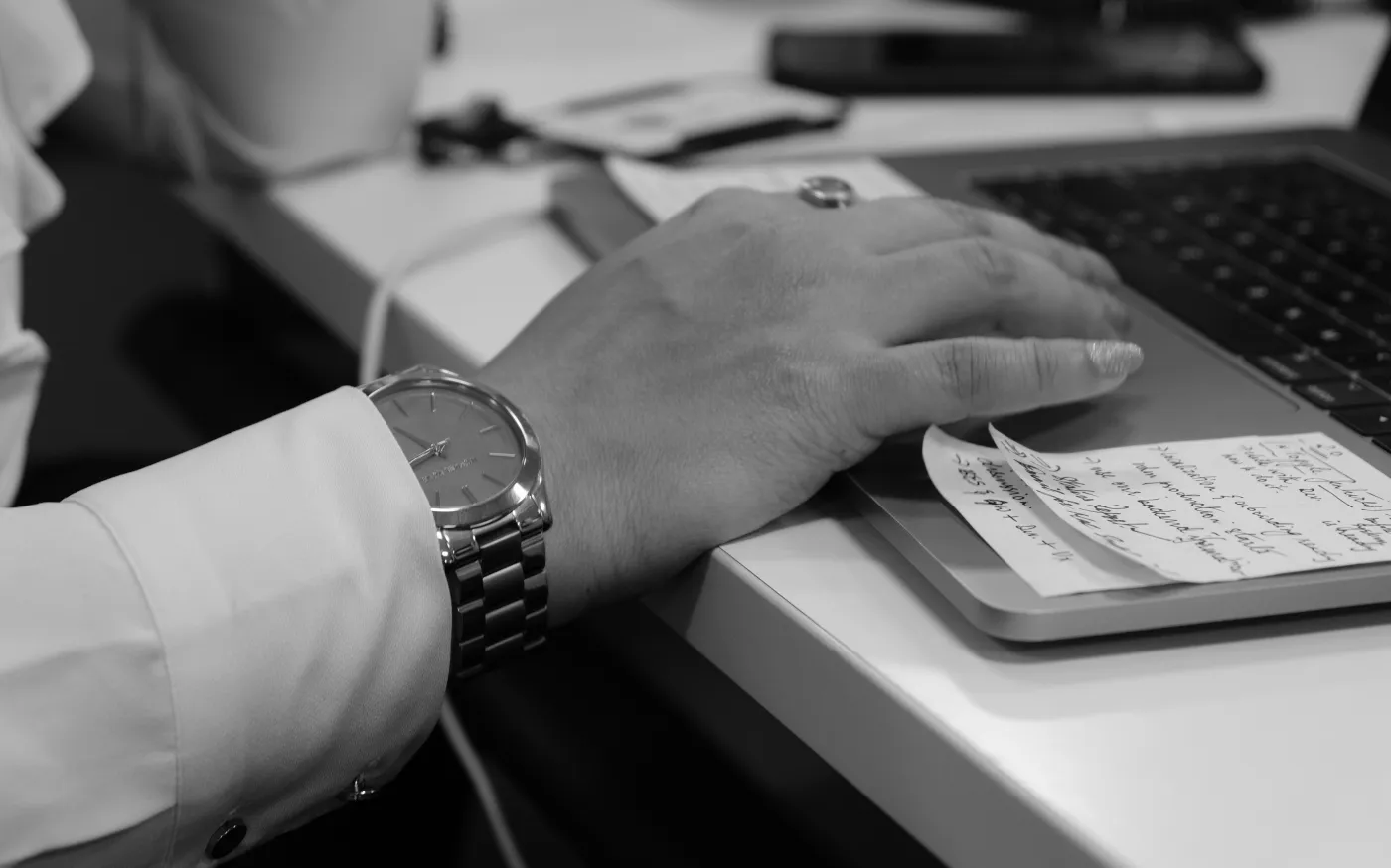 grayscale photo of person's hand on laptop by Praveen Kumar courtesy of Unsplash.