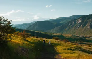 boy and man walking on mountain hill by Holly Mandarich courtesy of Unsplash.