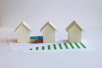 three small houses sitting on top of a piece of paper by Artful Homes courtesy of Unsplash.