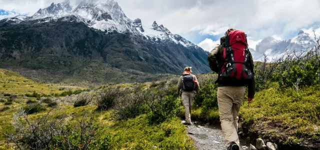 two person walking towards mountain covered with snow by Toomas Tartes courtesy of Unsplash.